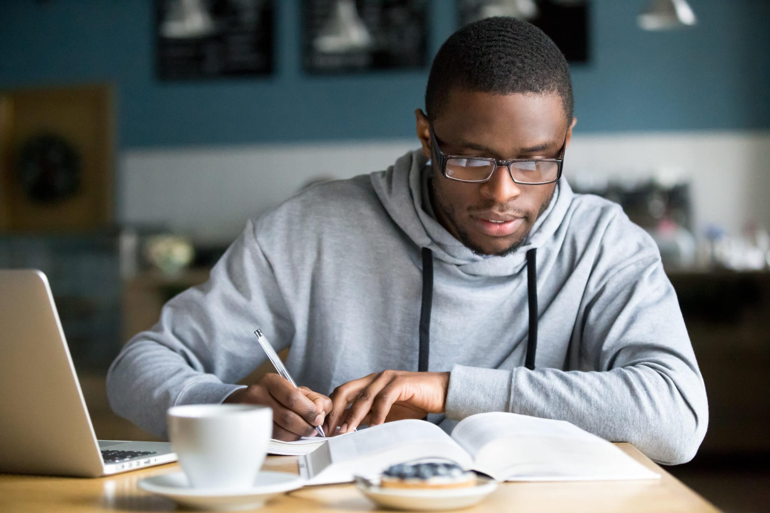 college student in glasses making notes on savings