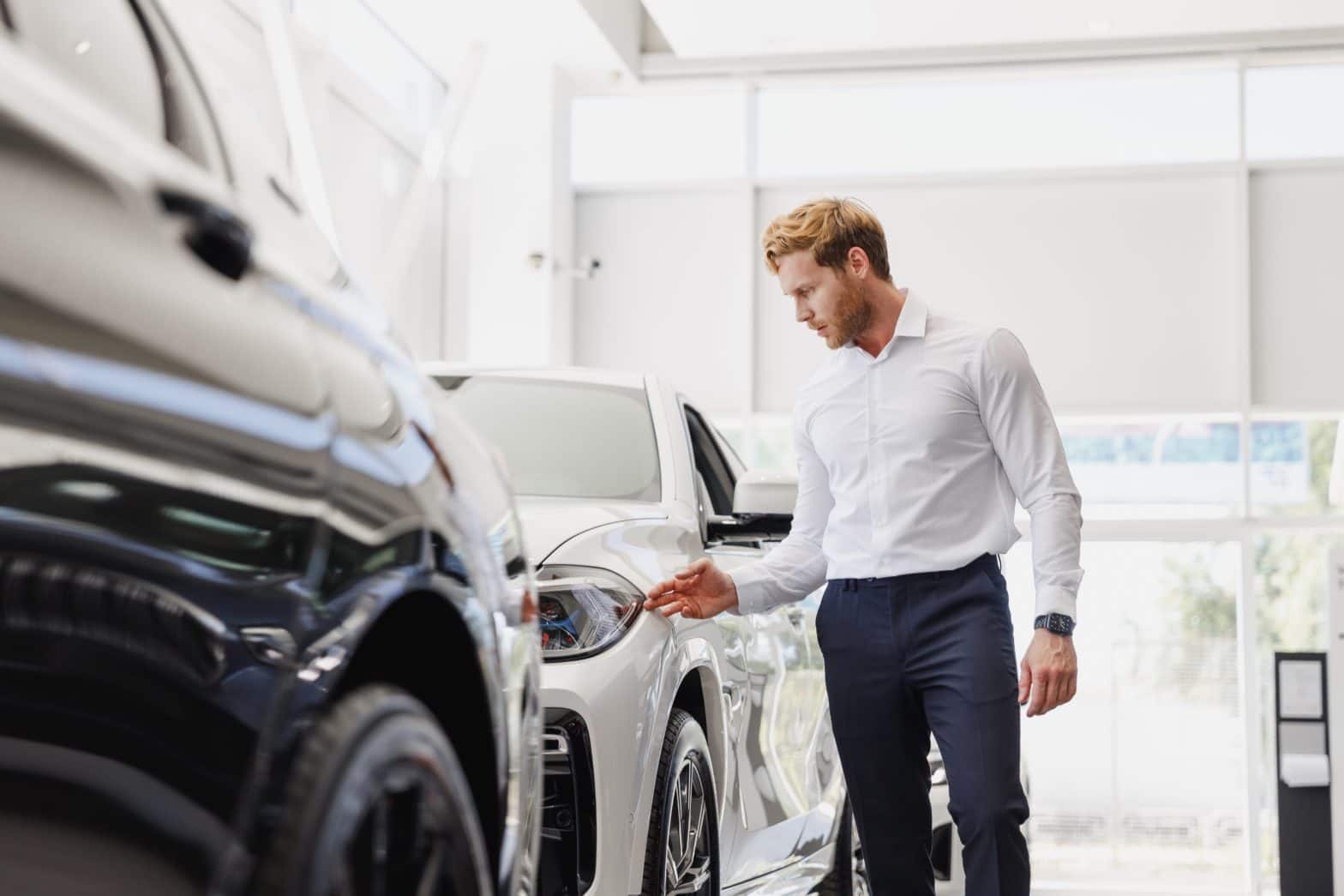 Men in white shirt checking expensive car to buy