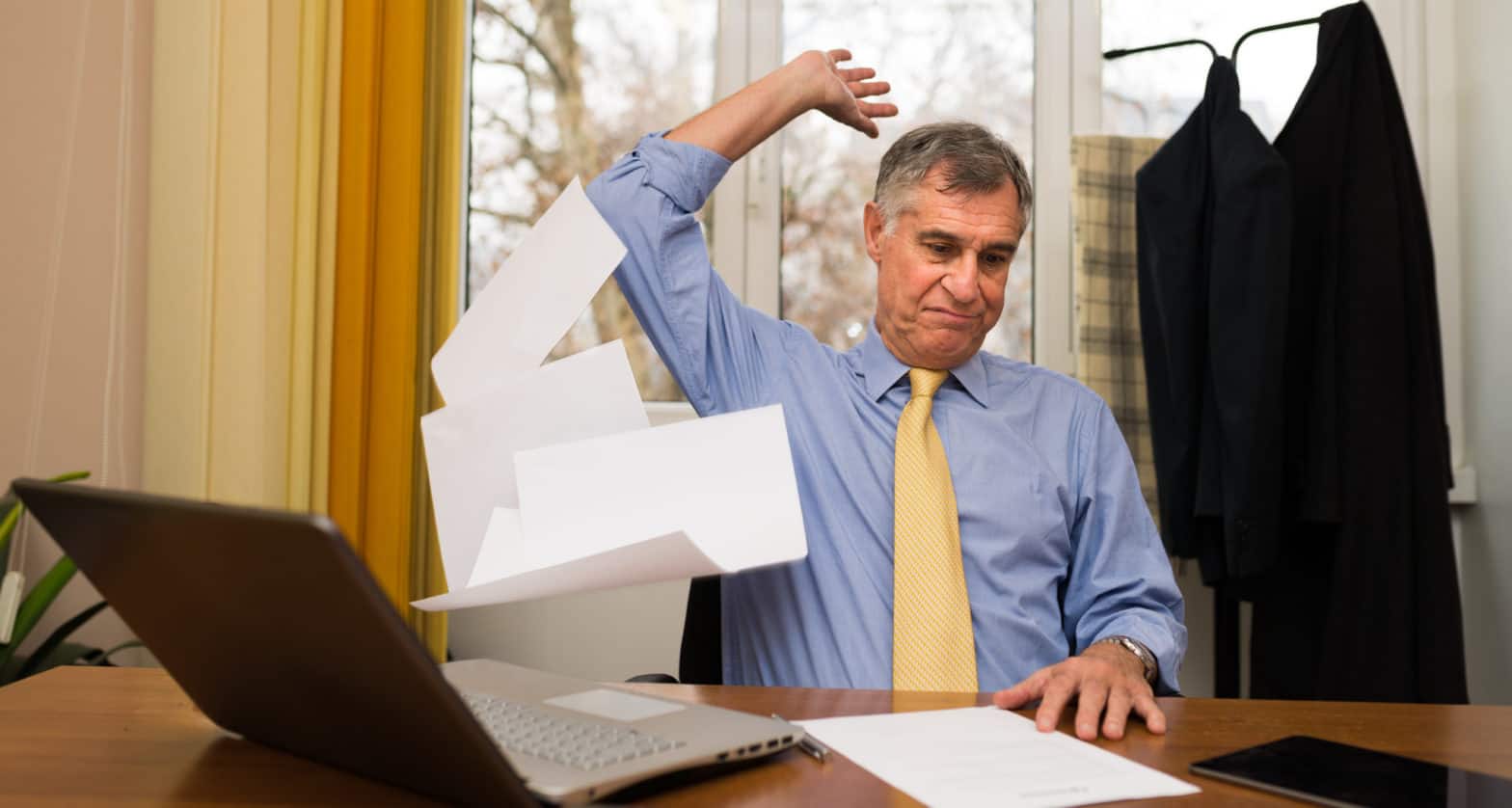 man throwing away paper sheets in his office