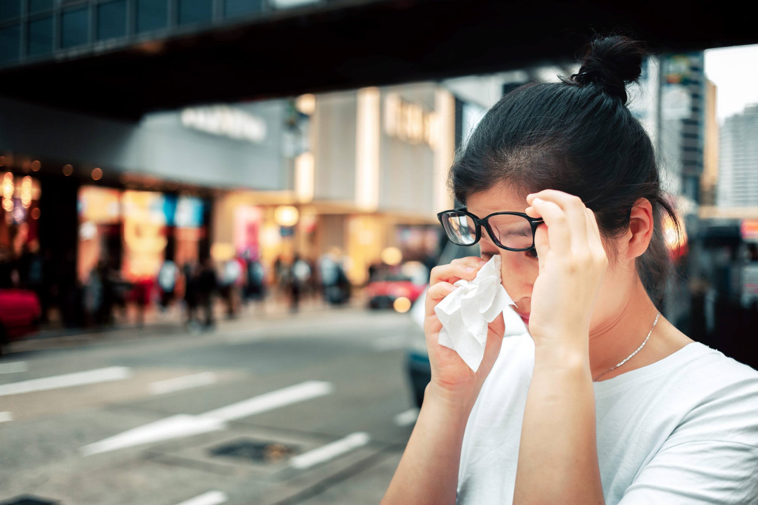 woman feel sick and sneeze on street