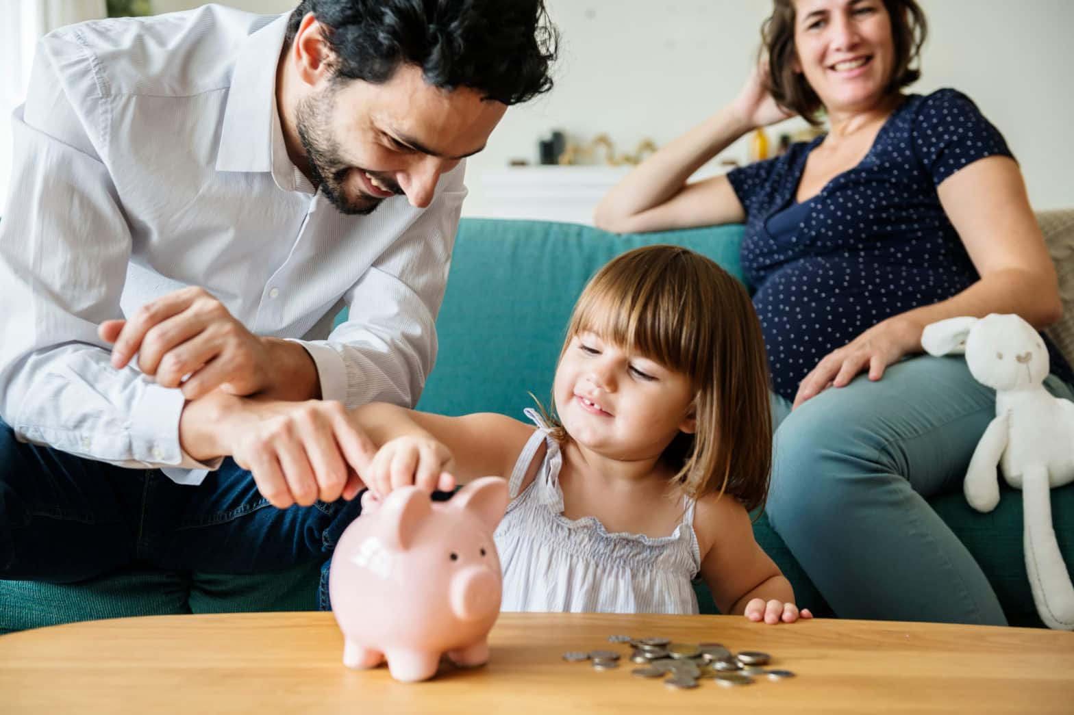 family saving money in piggy bank