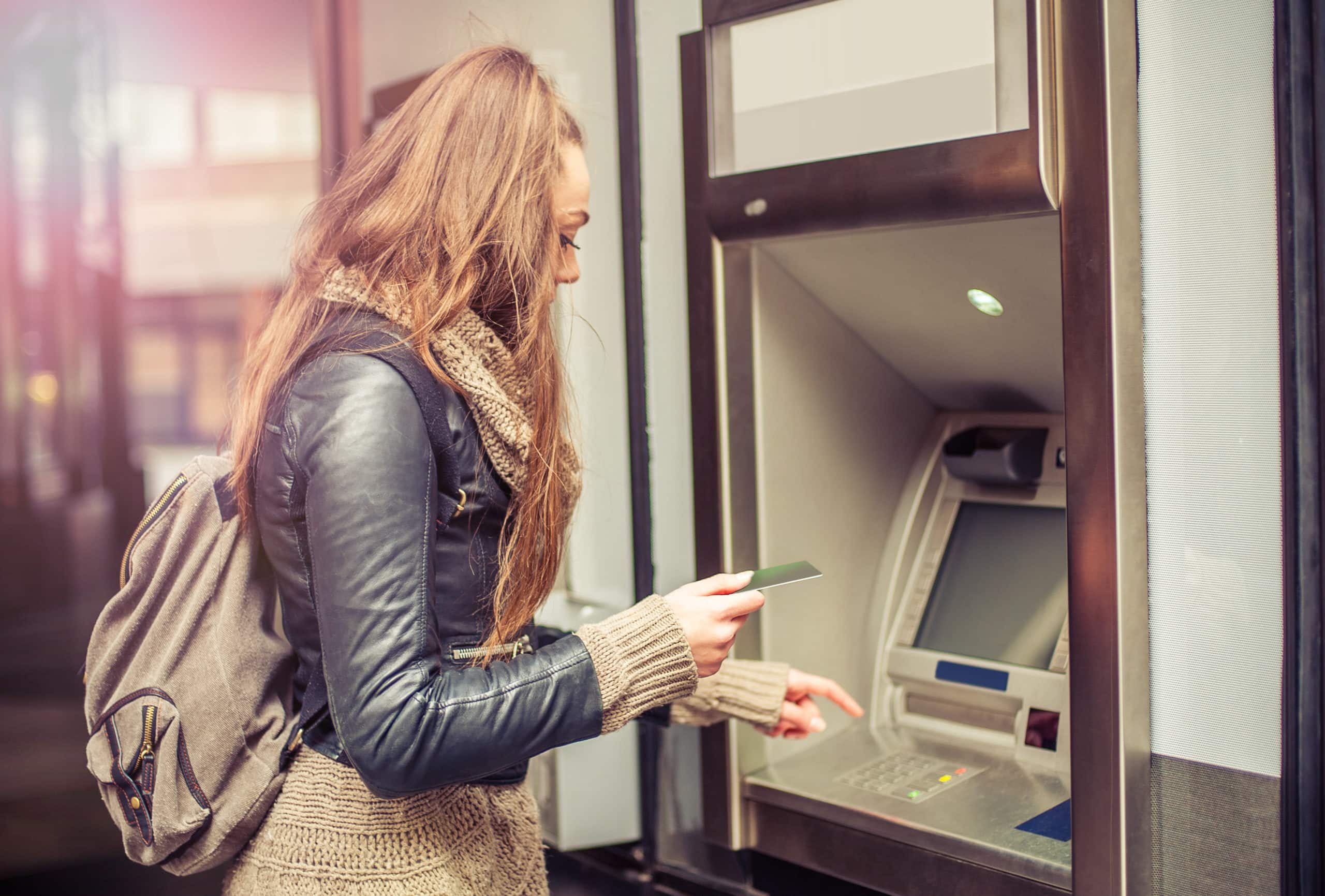 Young woman withdrawing money from ATM