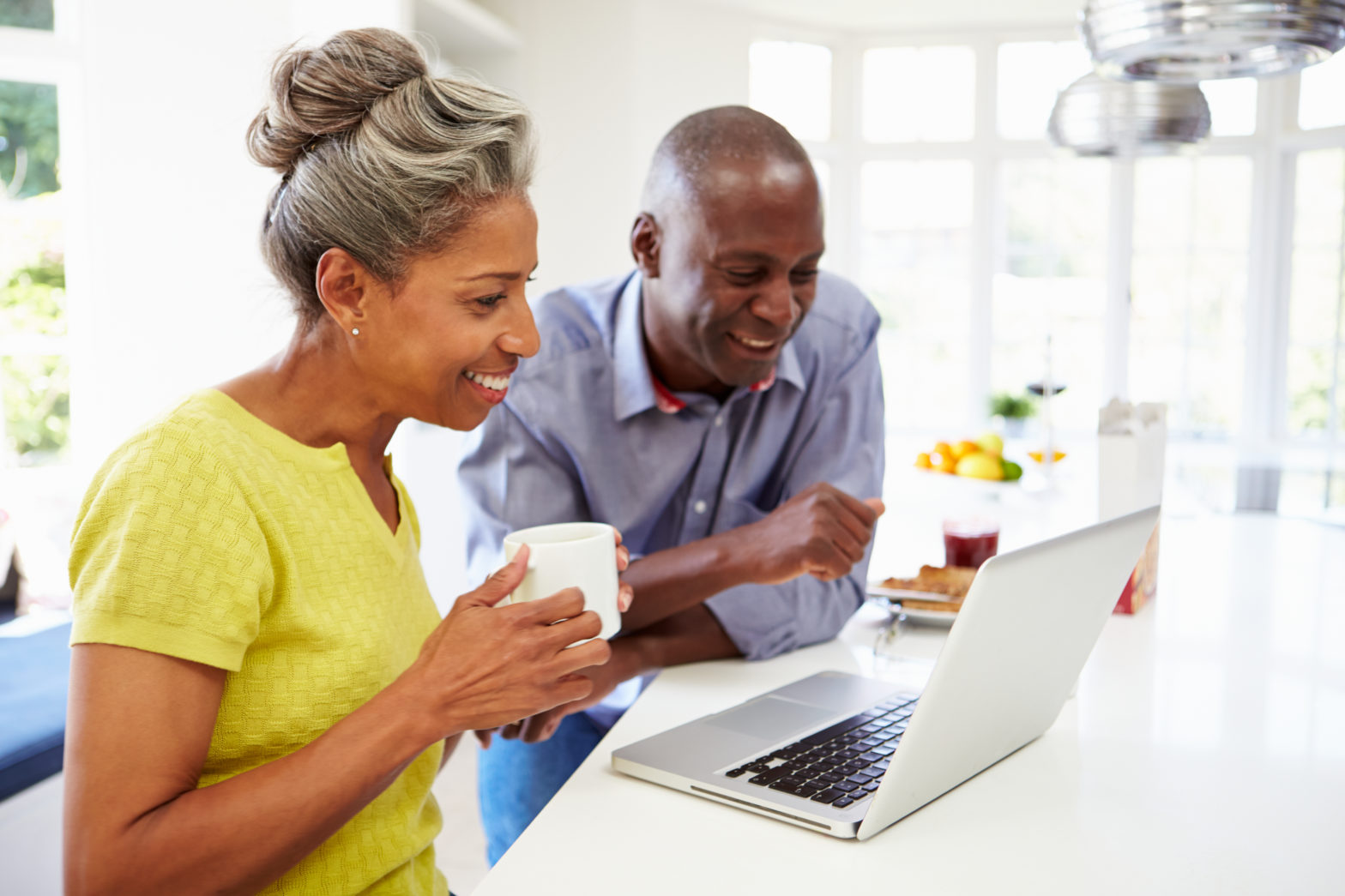 Couple using laptop at breakfast to check about certificate of deposit within IRA