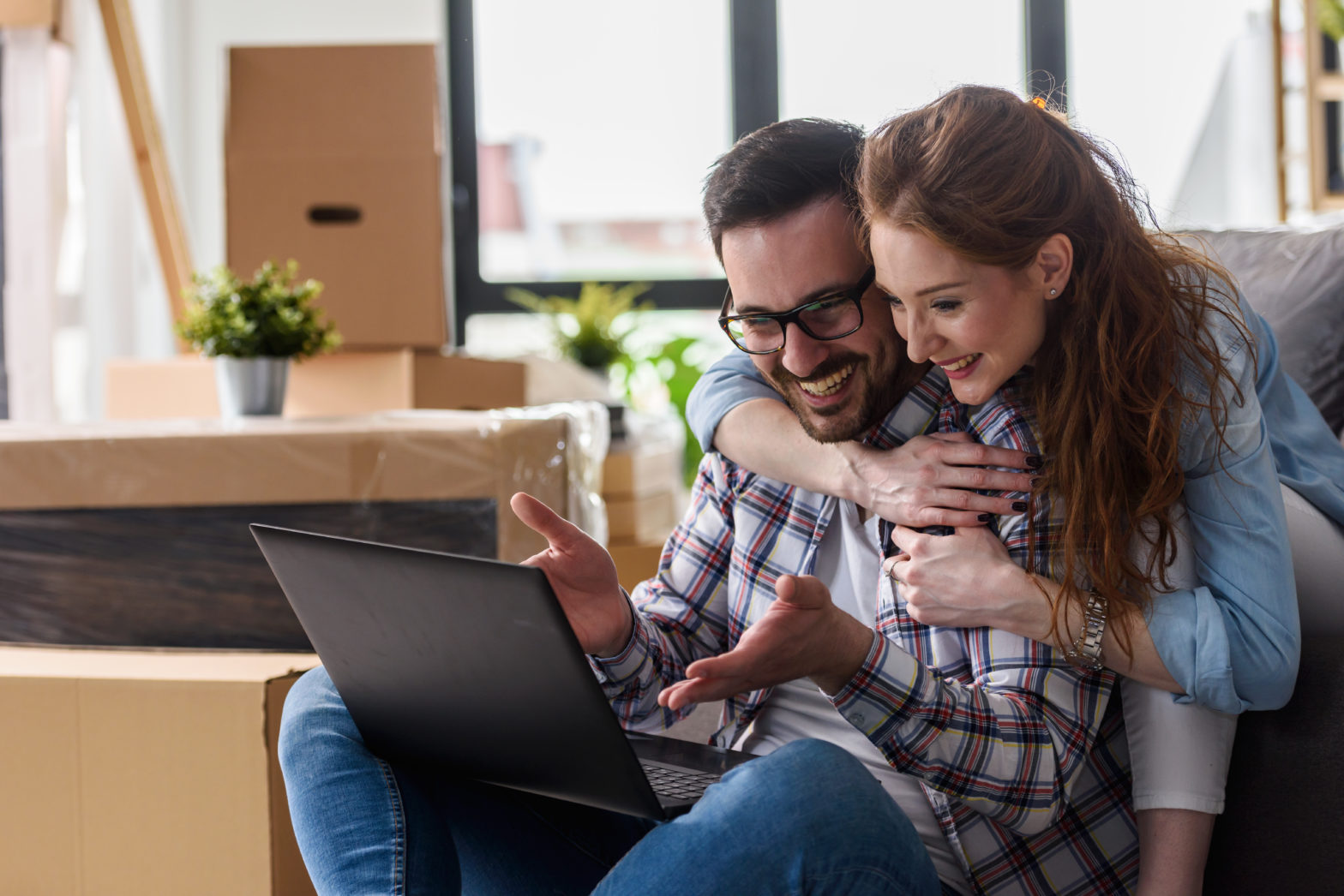 Young couple checking compounded interest on savings account through laptop