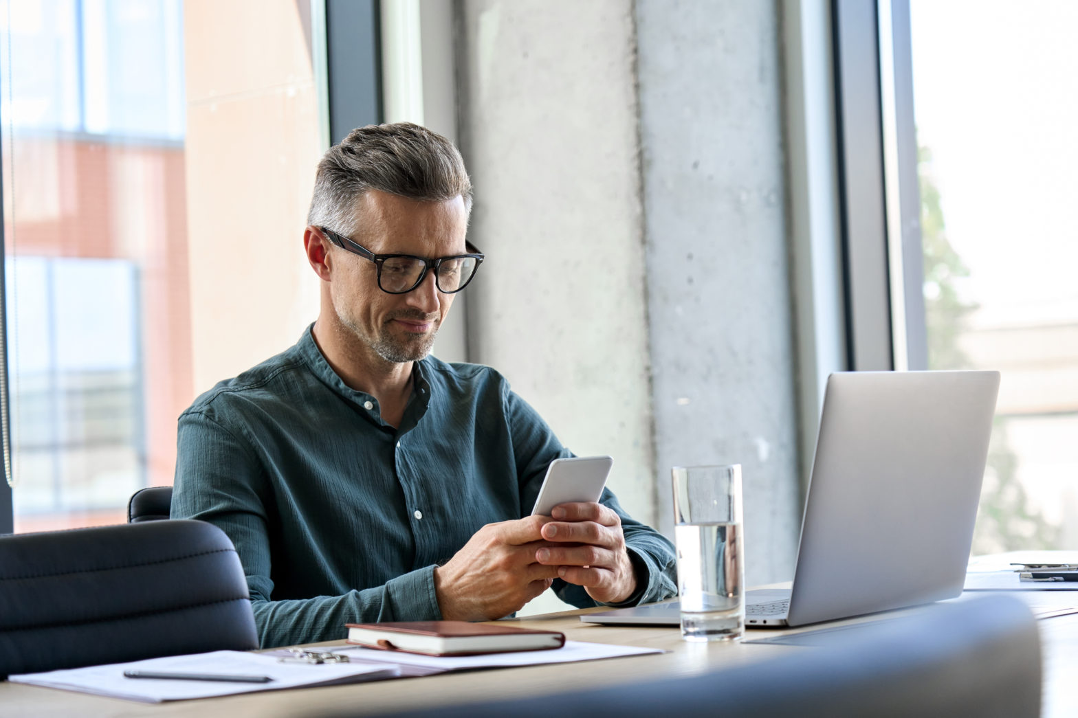 businessman holding a smartphone sitting in office