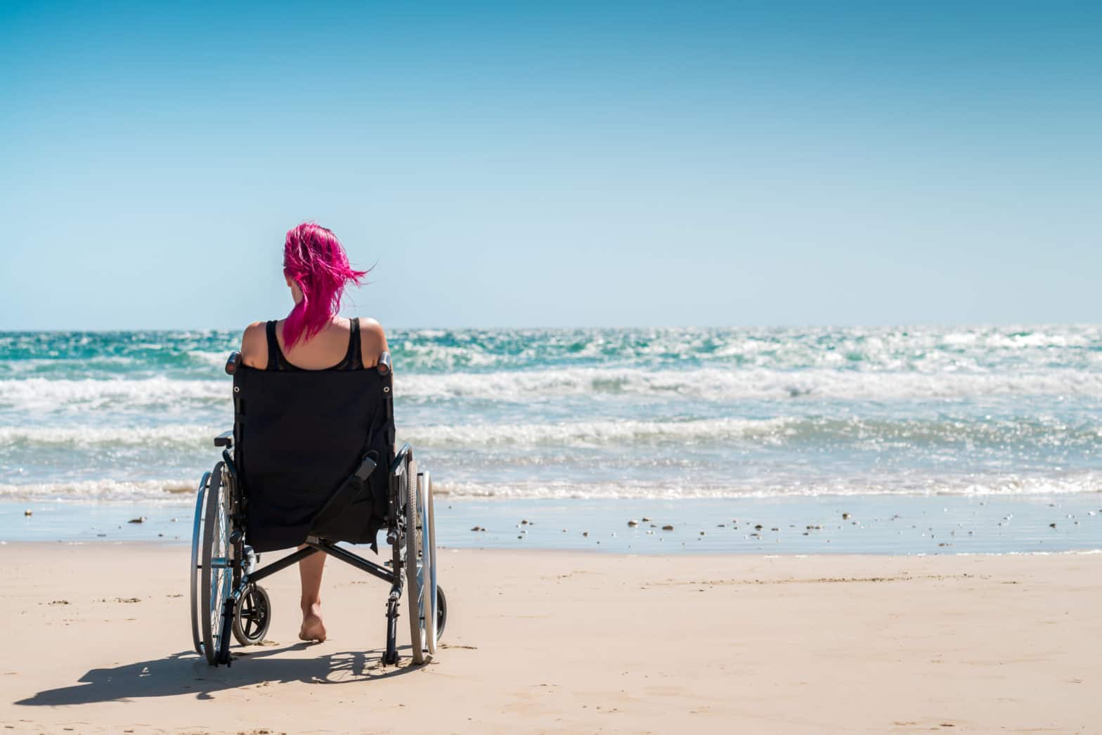 woman using wheelchair at the beach