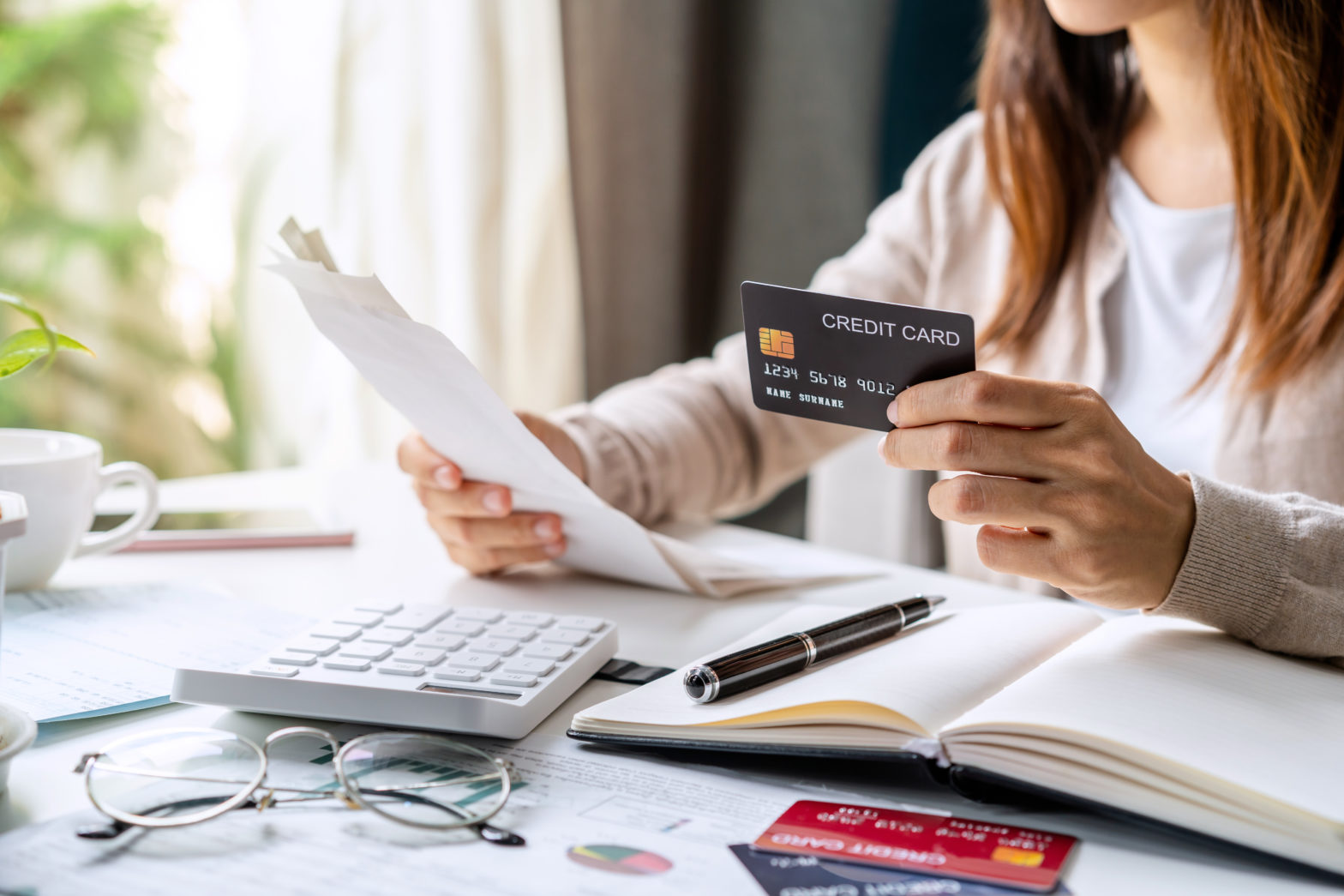 stressed young woman calculating monthly credit card expenses