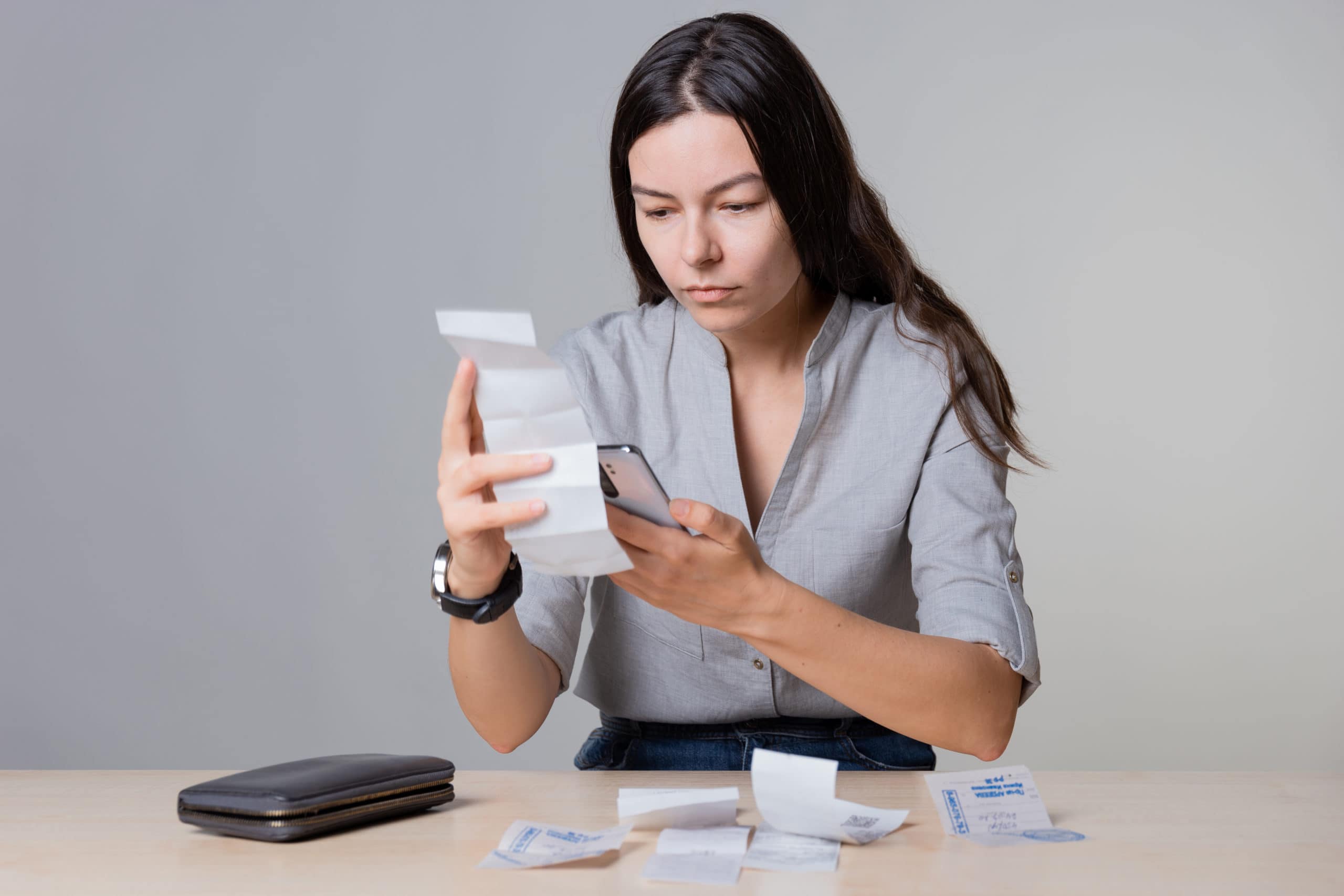 woman considers the personal loan and holds receipts and invoices