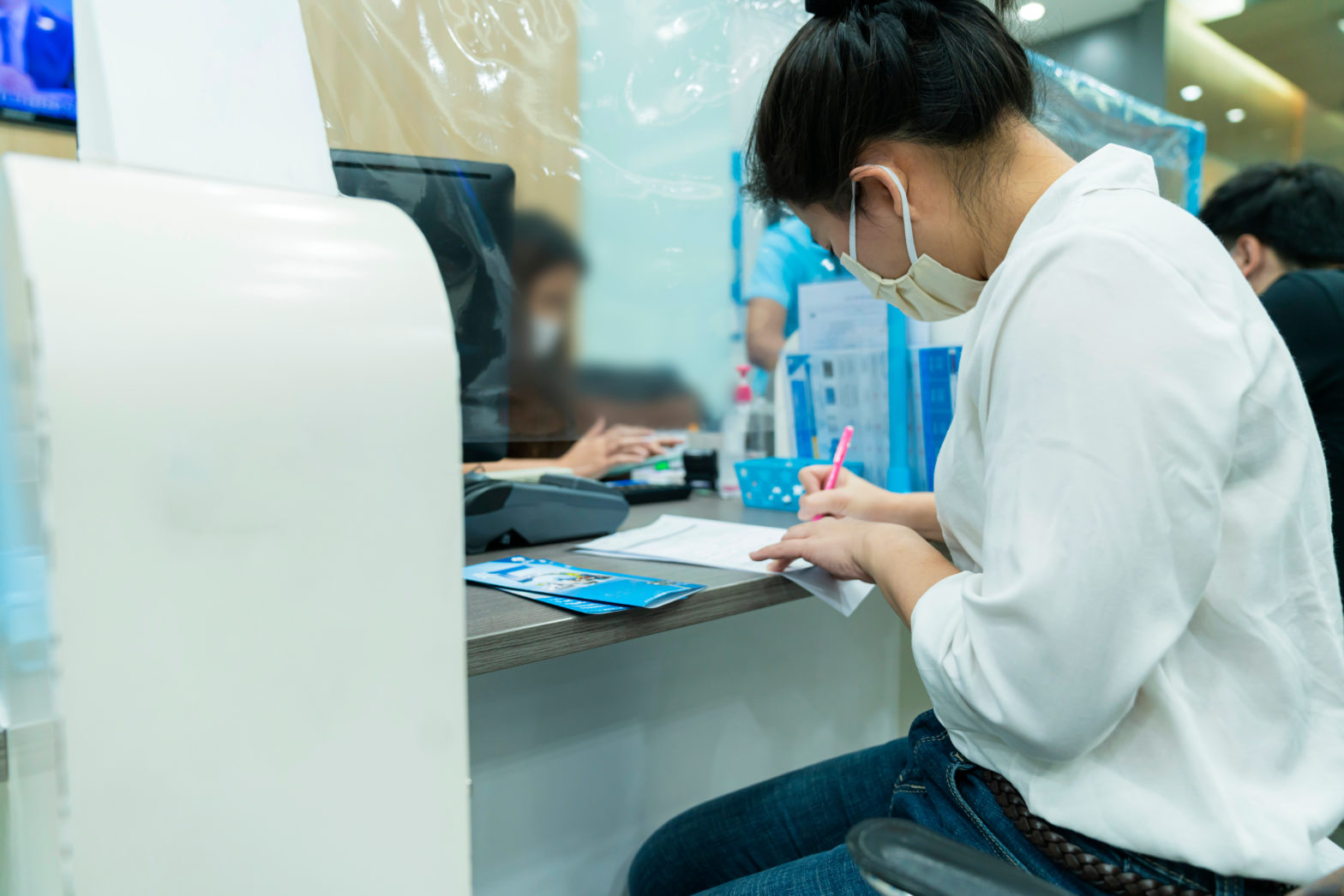 woman sit and writing on paper at bank