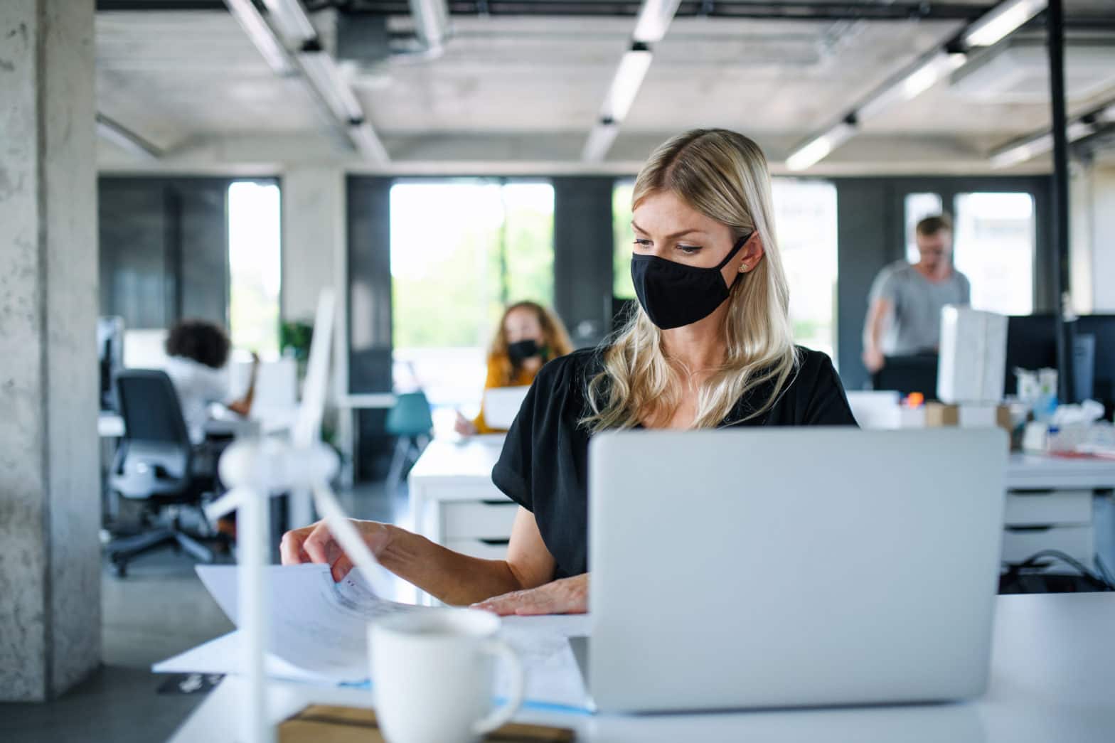 woman with face mask back at work in office