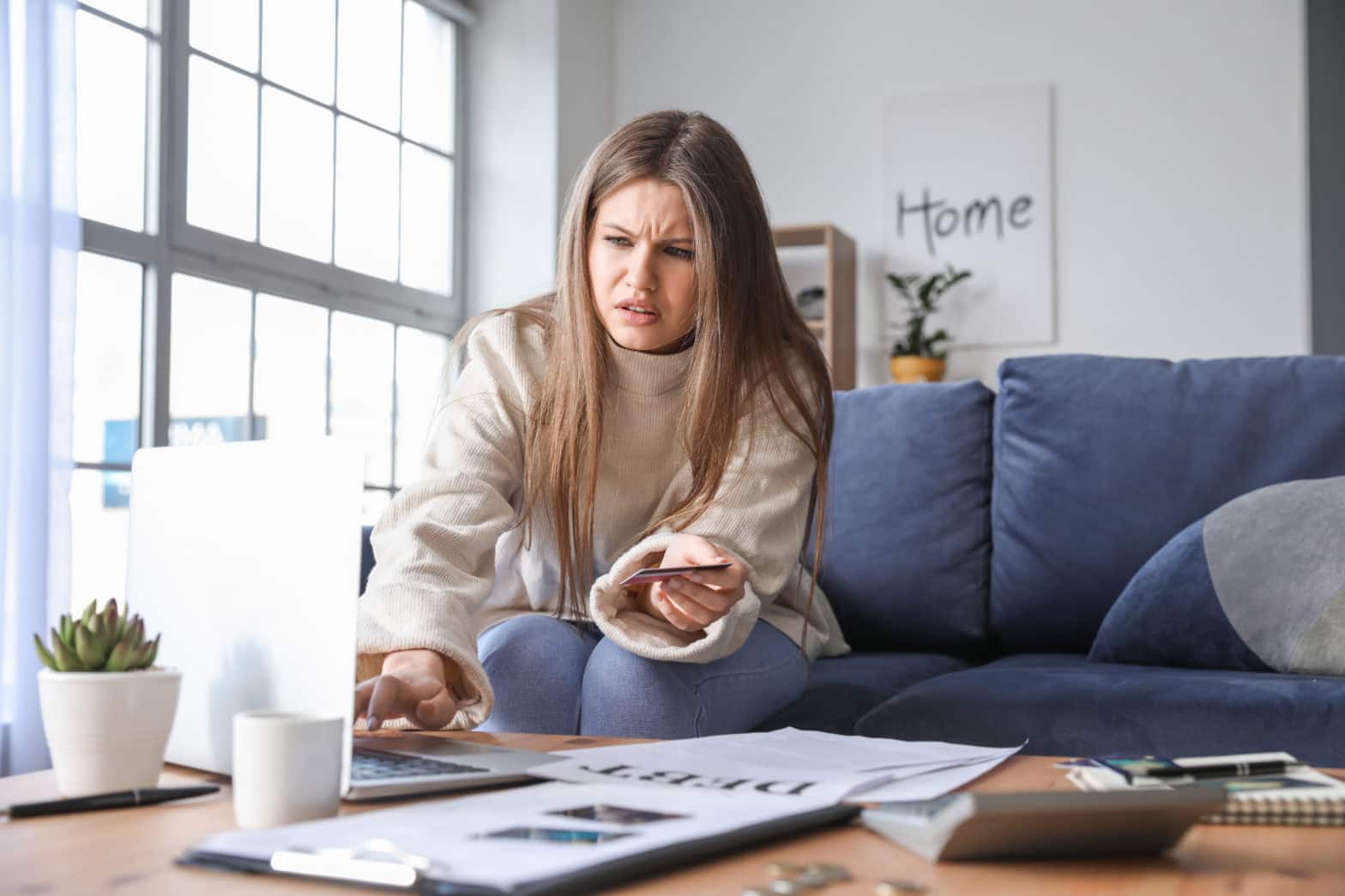 worried young woman in debt at home