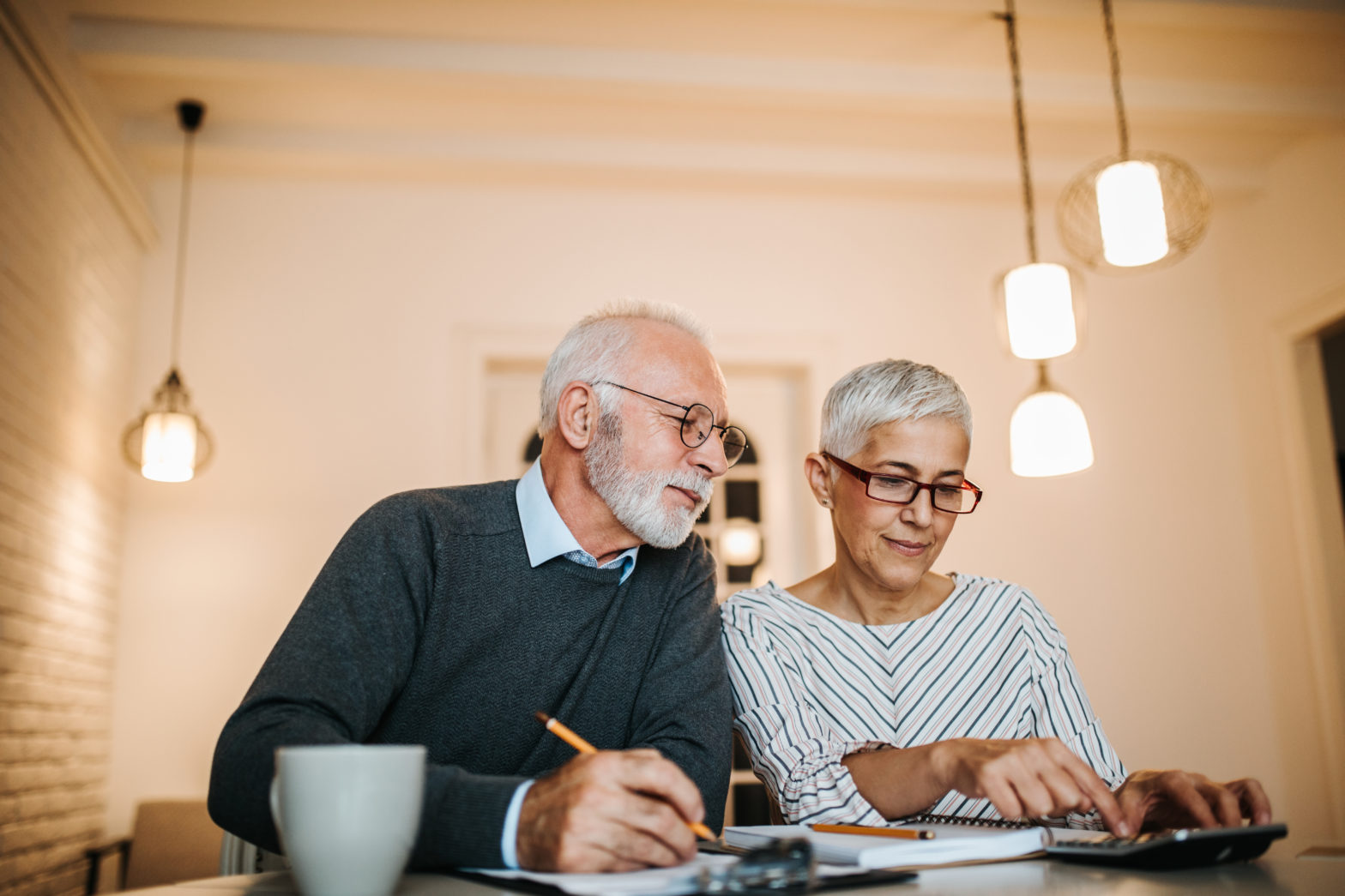 old couple doing some retirement savings targets calculations at home