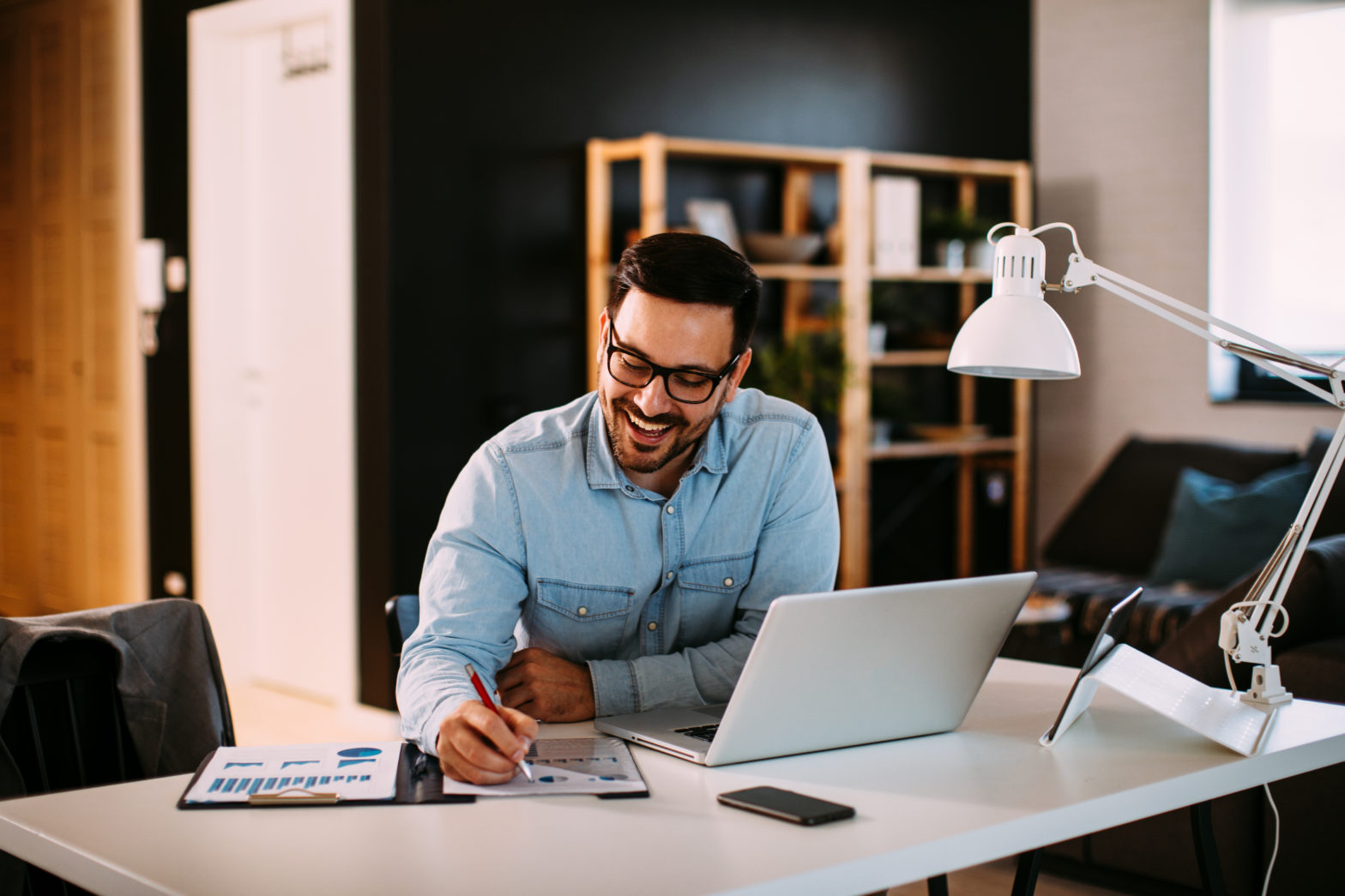 Men happily holding pen and deciding asset allocation with laptop at the desk