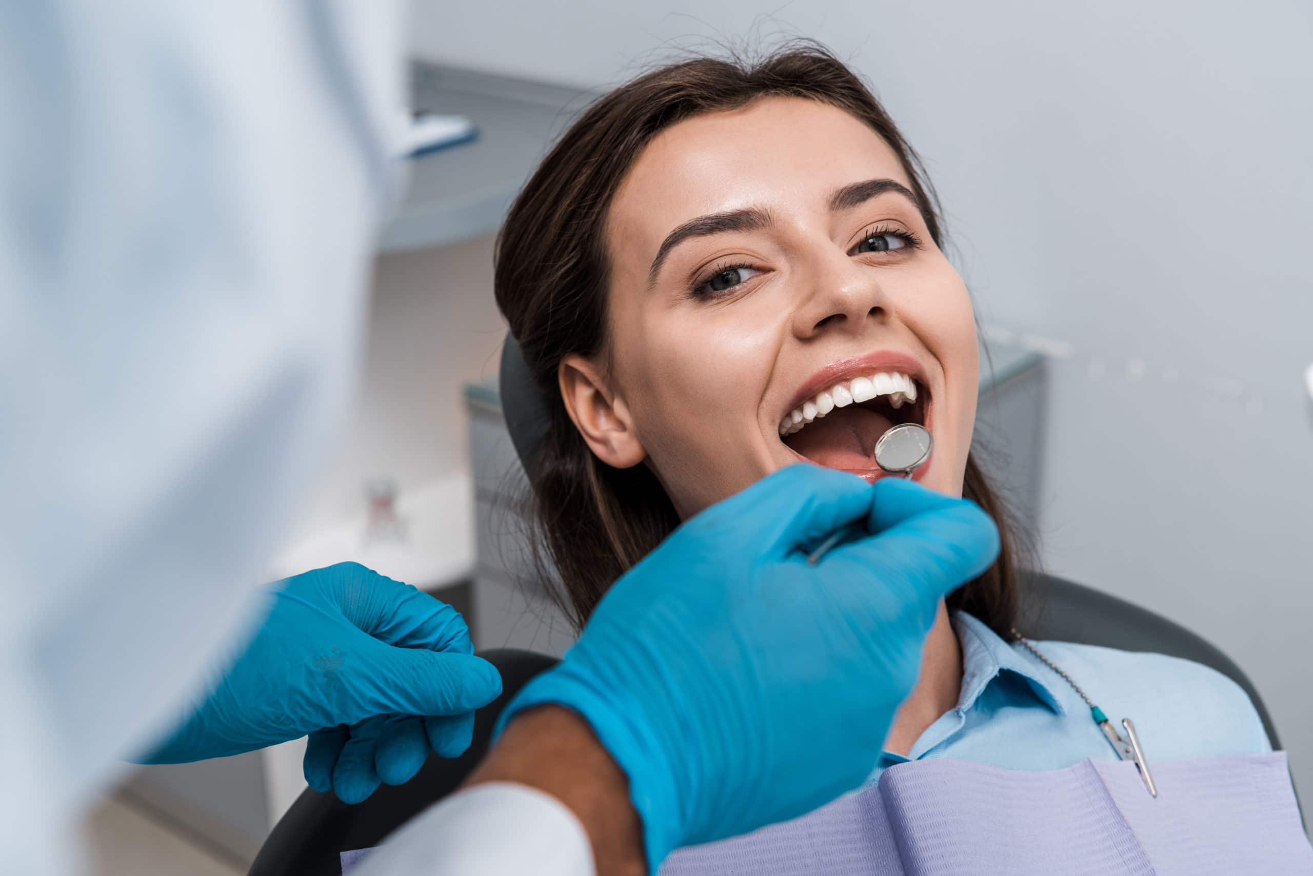 selective focus of dentist in latex gloves holding a dental mirror