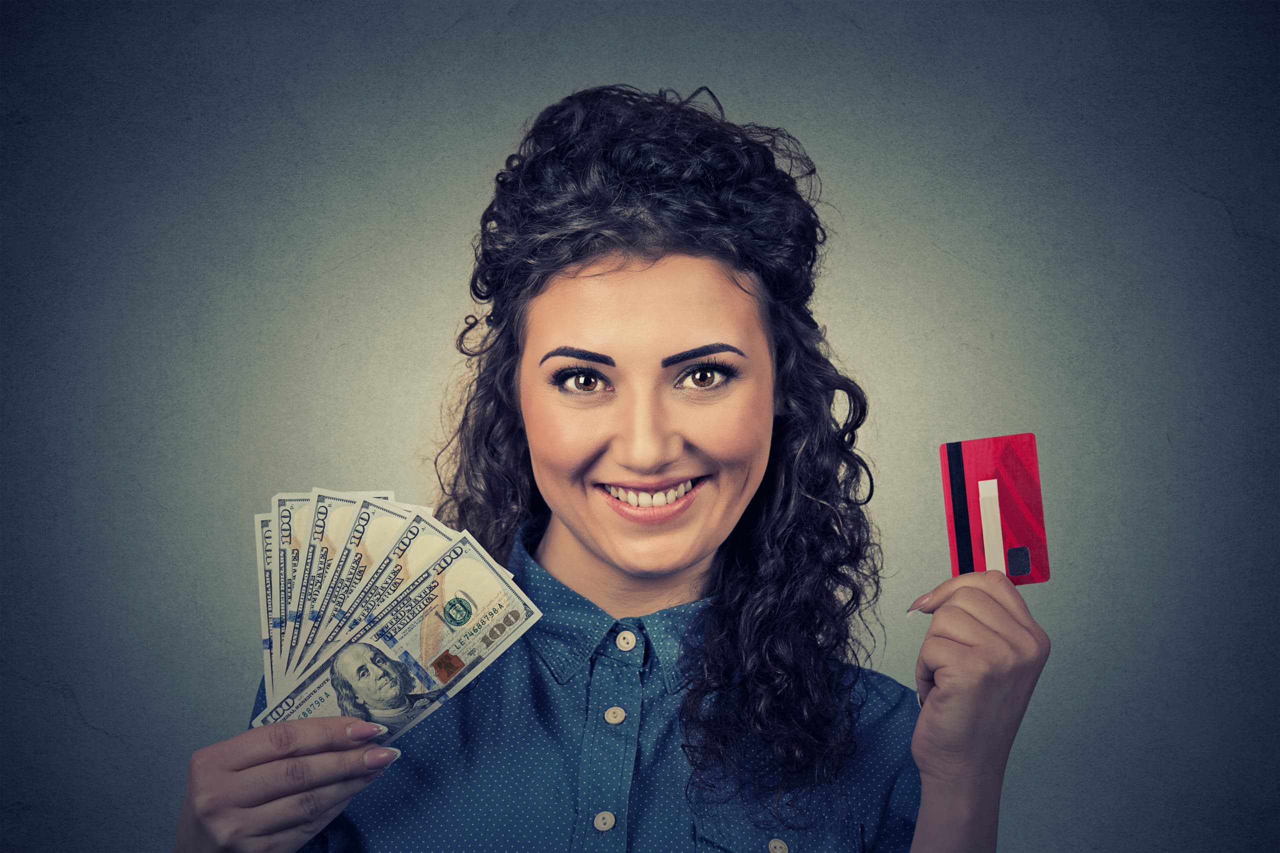 young woman holding showing advance credit card cash