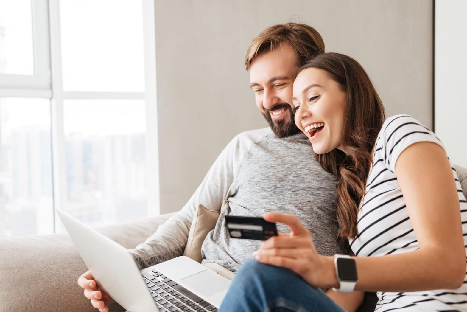 couple shopping online with a credit card while sitting at home