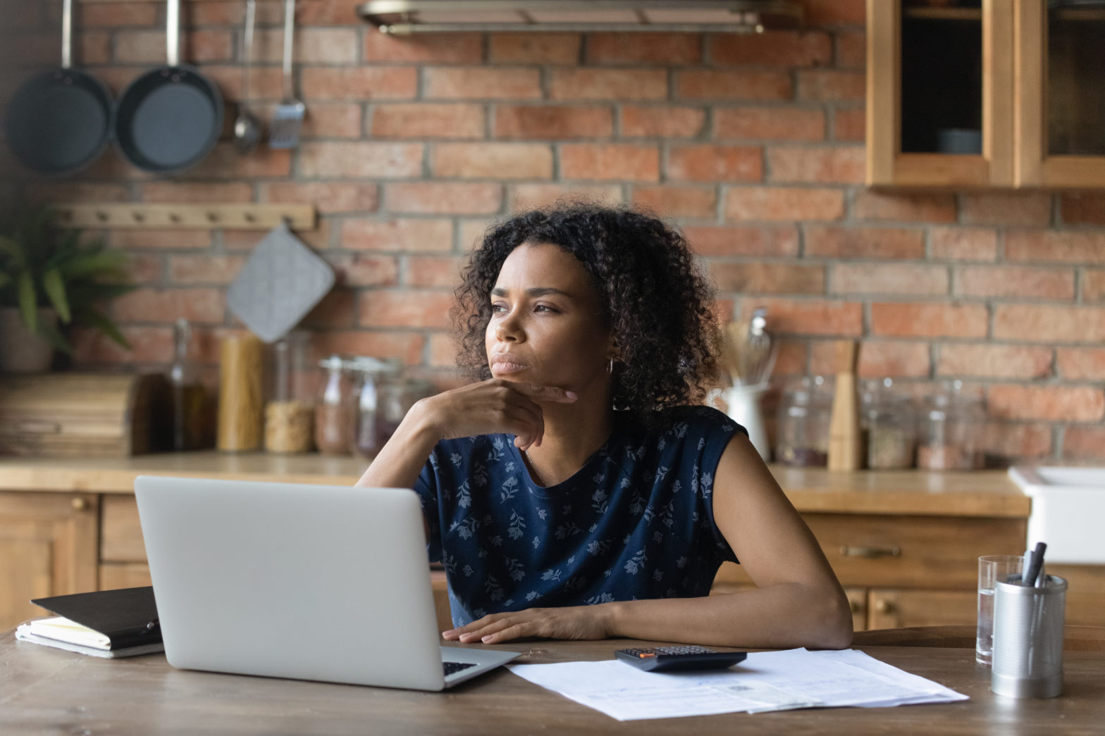 woman touching chin sitting and thinking about savings accounts
