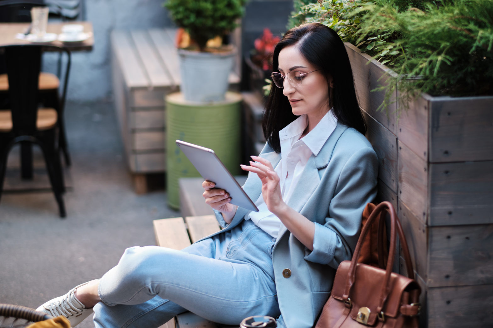 businesswoman working with tablet doing online banking at city cafe