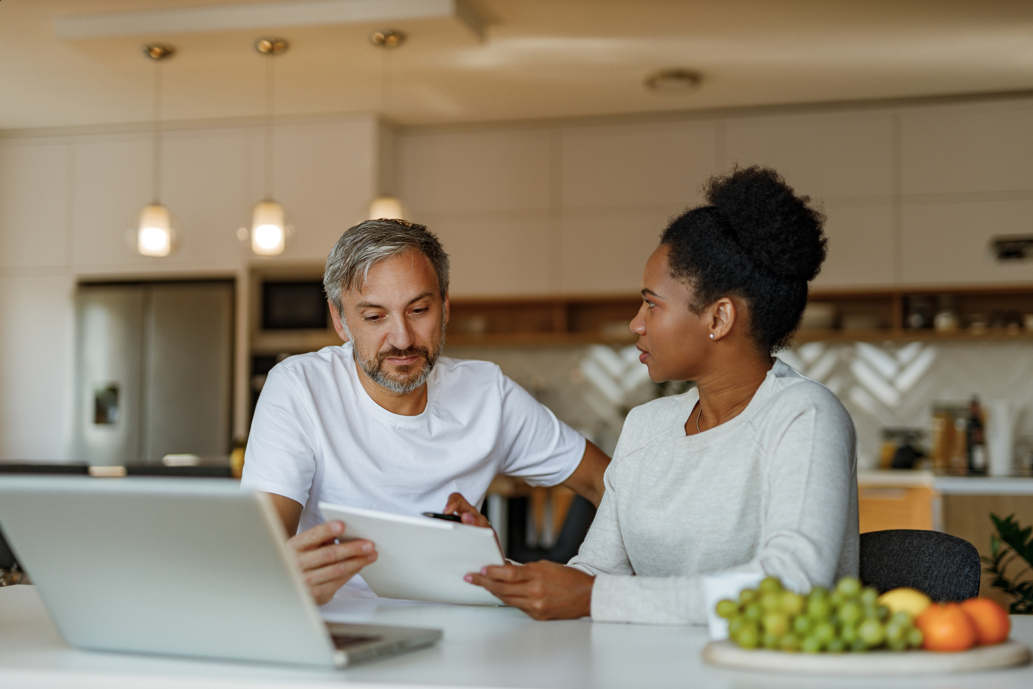 A couple is sitting at a computer discussing paying their taxes