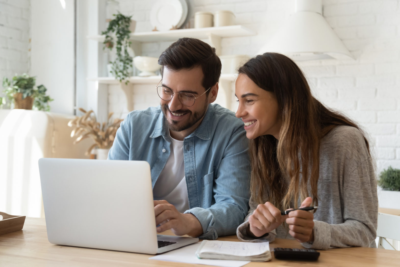 A young couple uses a laptop computer to research personal loan rates