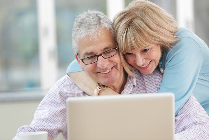 Older couple looking at laptop, happy with their retirement plans