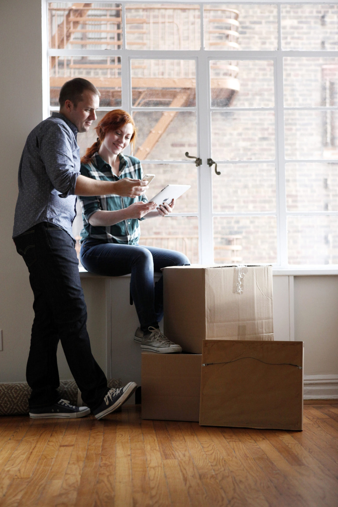 A couple check their phone and tablet to check on their investments