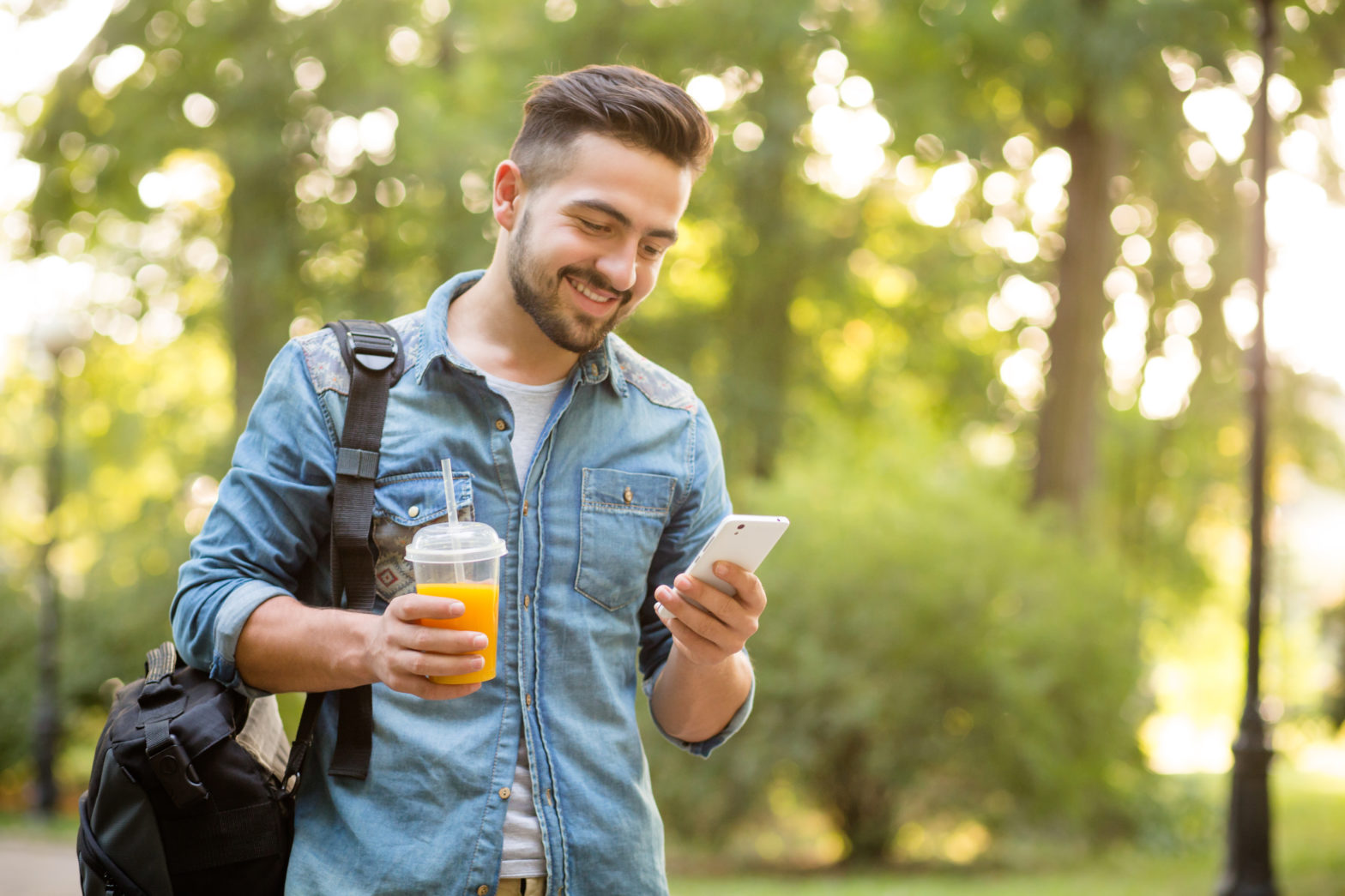 Happy hipster man walking in autumn park and smiling short-haited