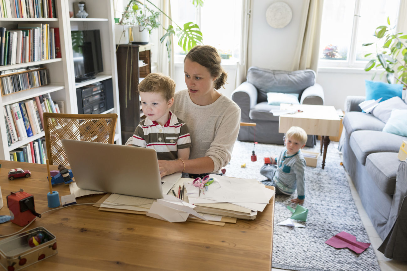A woman checks her money market account online while her son sits on her lap