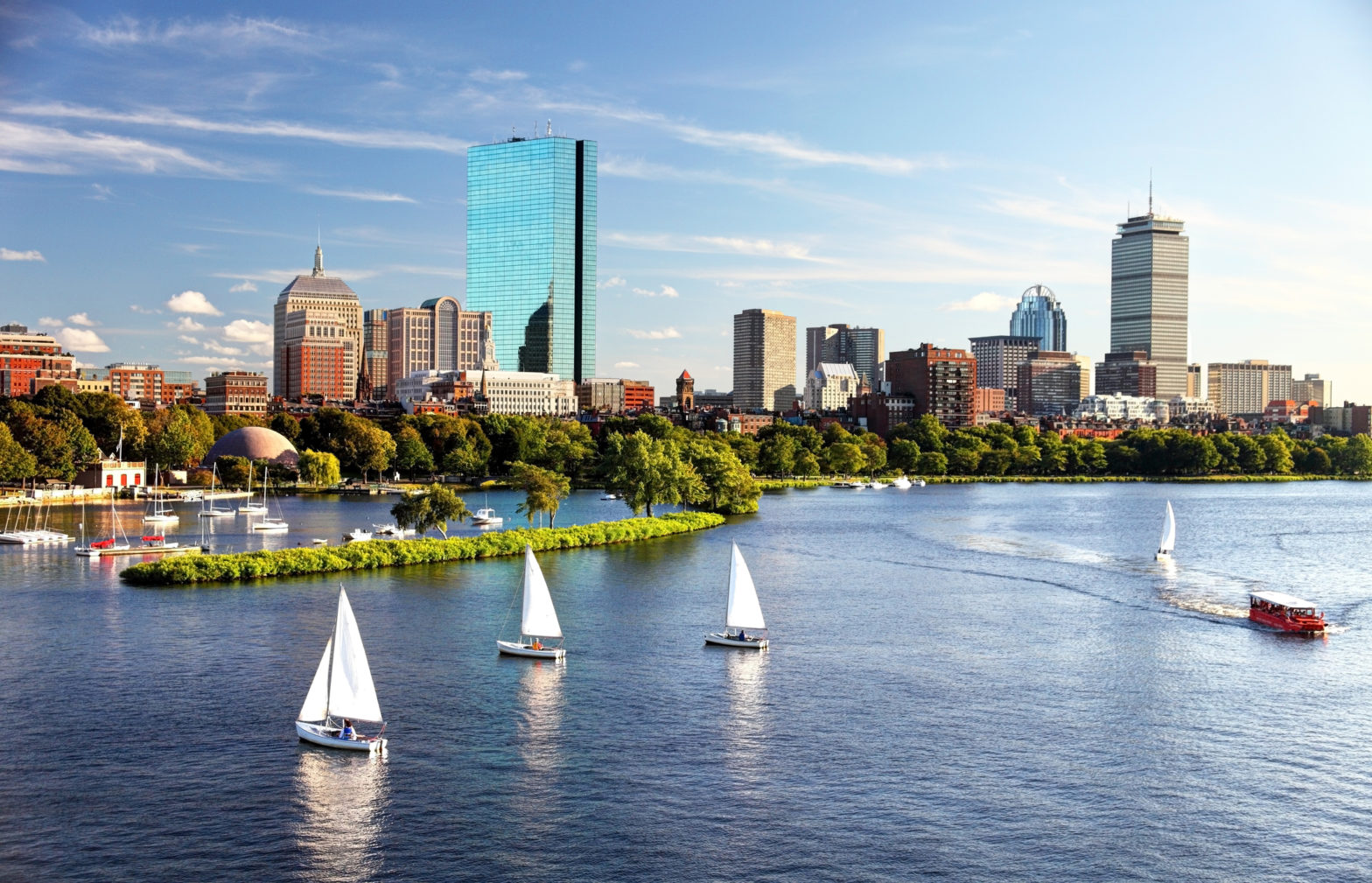 Boston skyline and Boston harbor featuring tall buildings and sailboats on the harbor