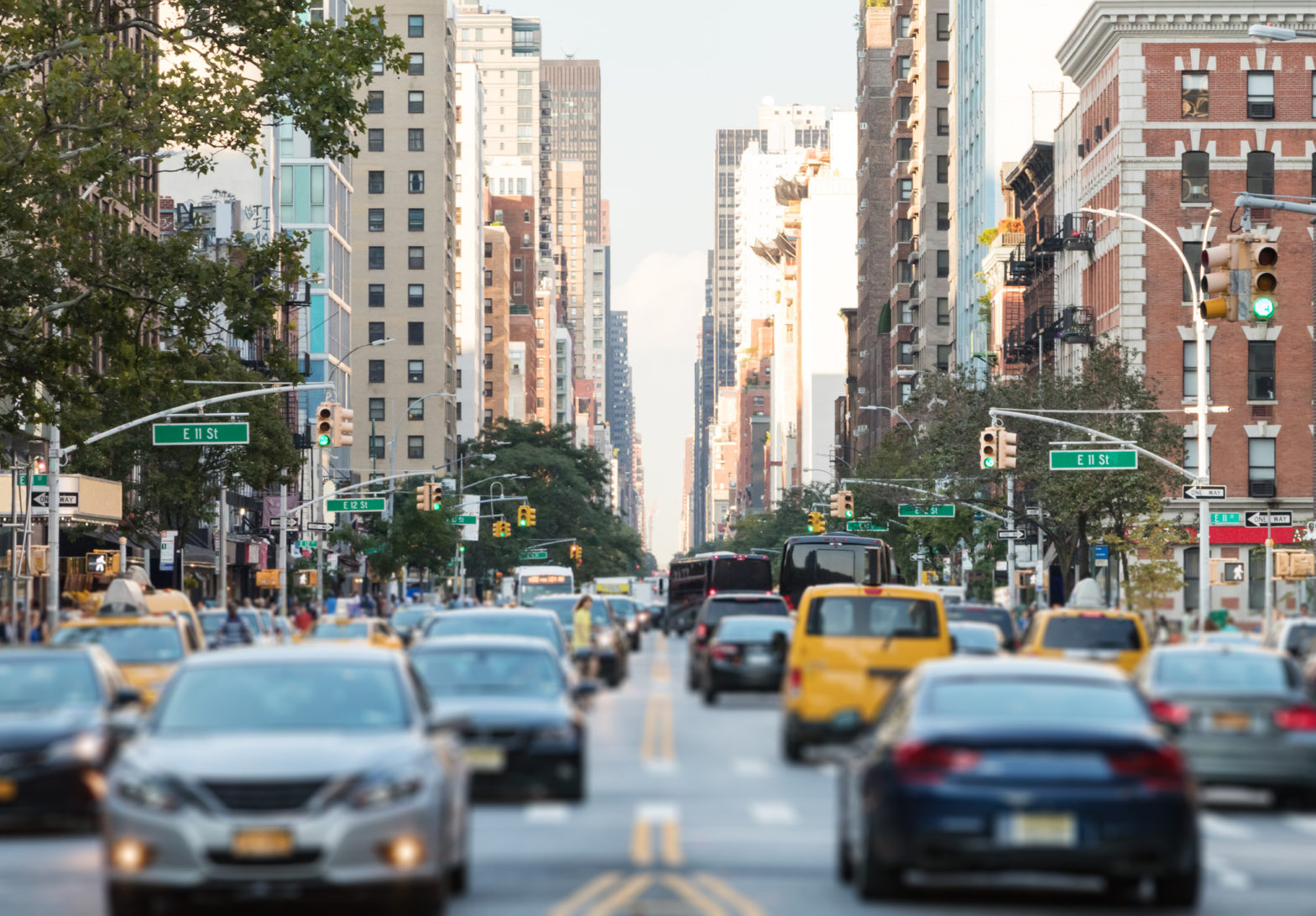 New York City busy street scene with cars and people along 3rd Avenue in the East Village of Manhattan