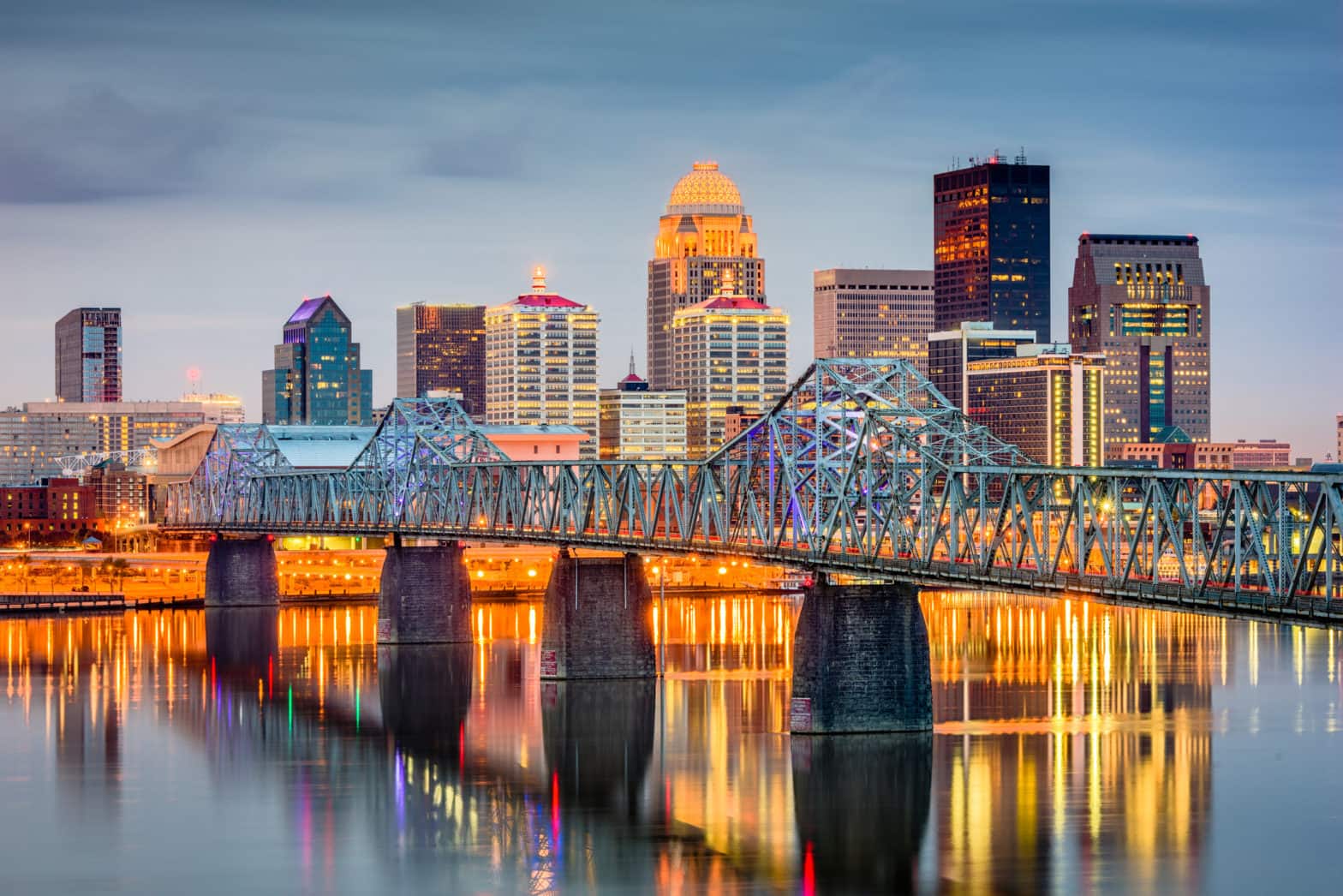 The Louisville, Kentucky skyline seen at dusk with the river and bridge in the foreground