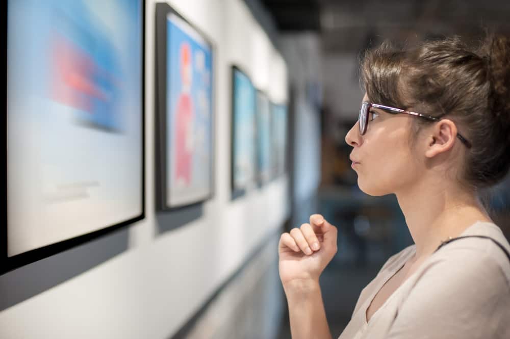 A woman looks at art in a museum