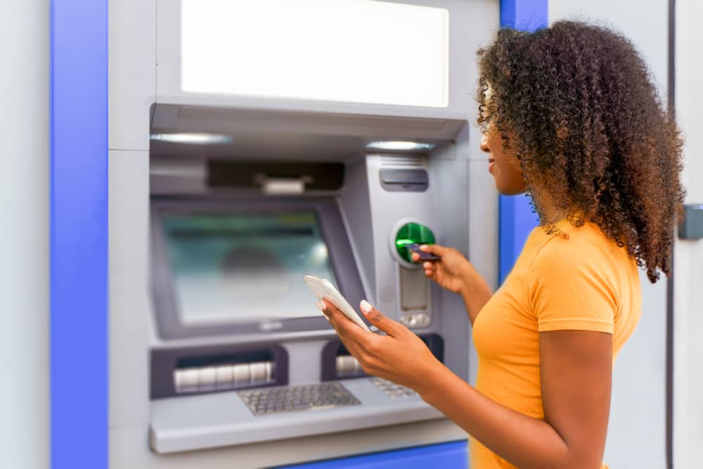 A woman visits an ATM to access her checking account