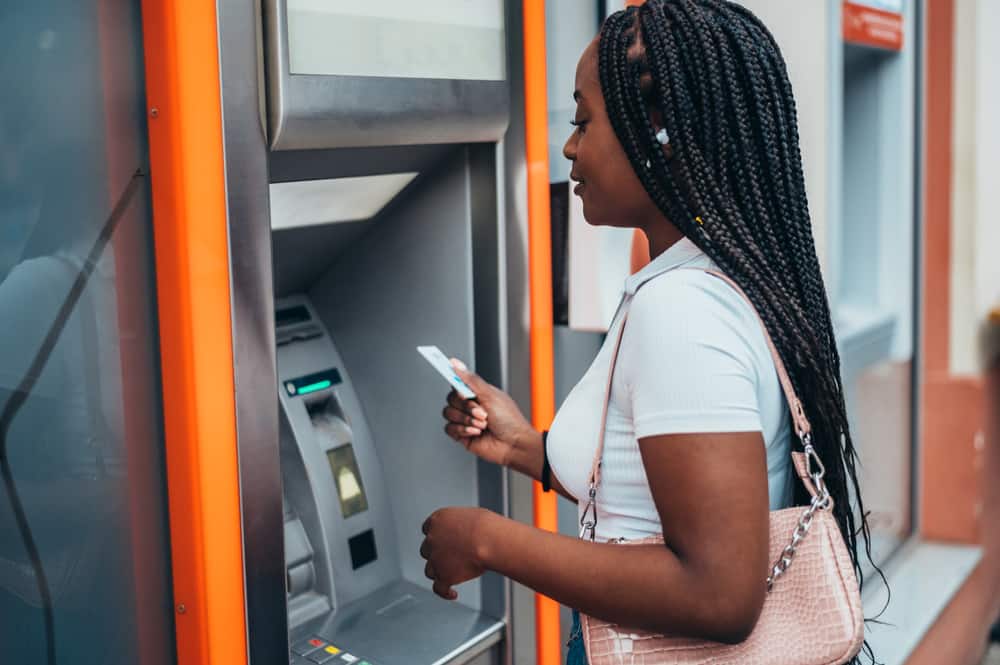 A young woman uses an ATM