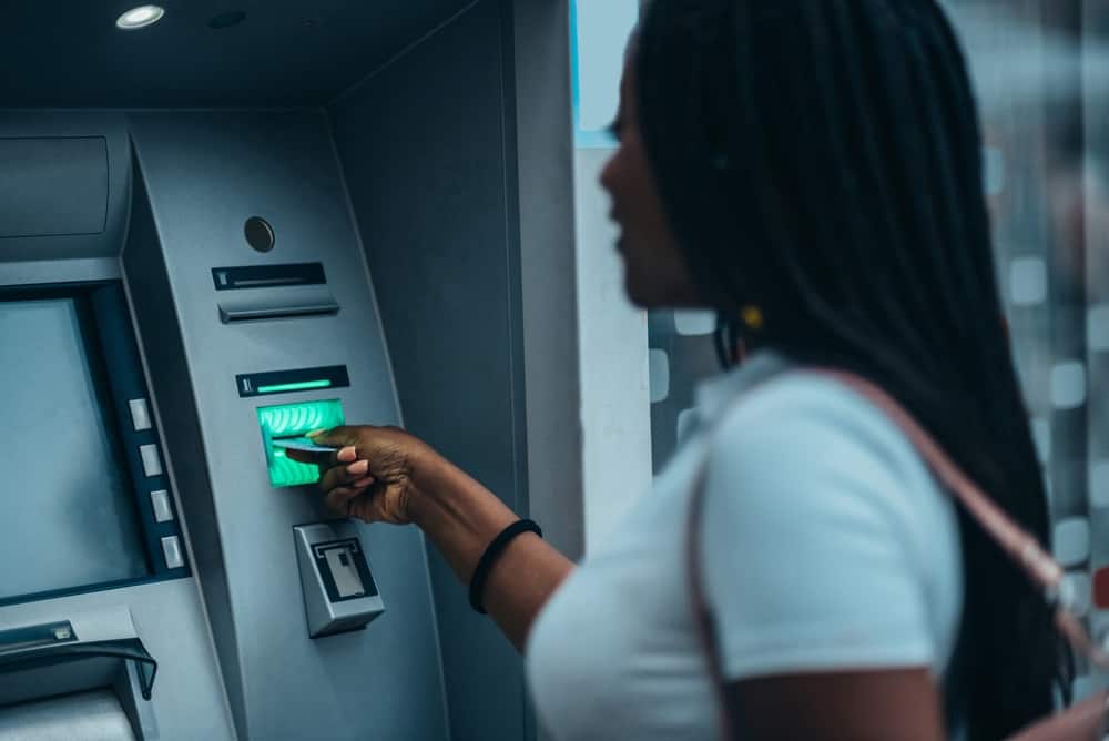 A woman uses an ATM to get money from her checking account