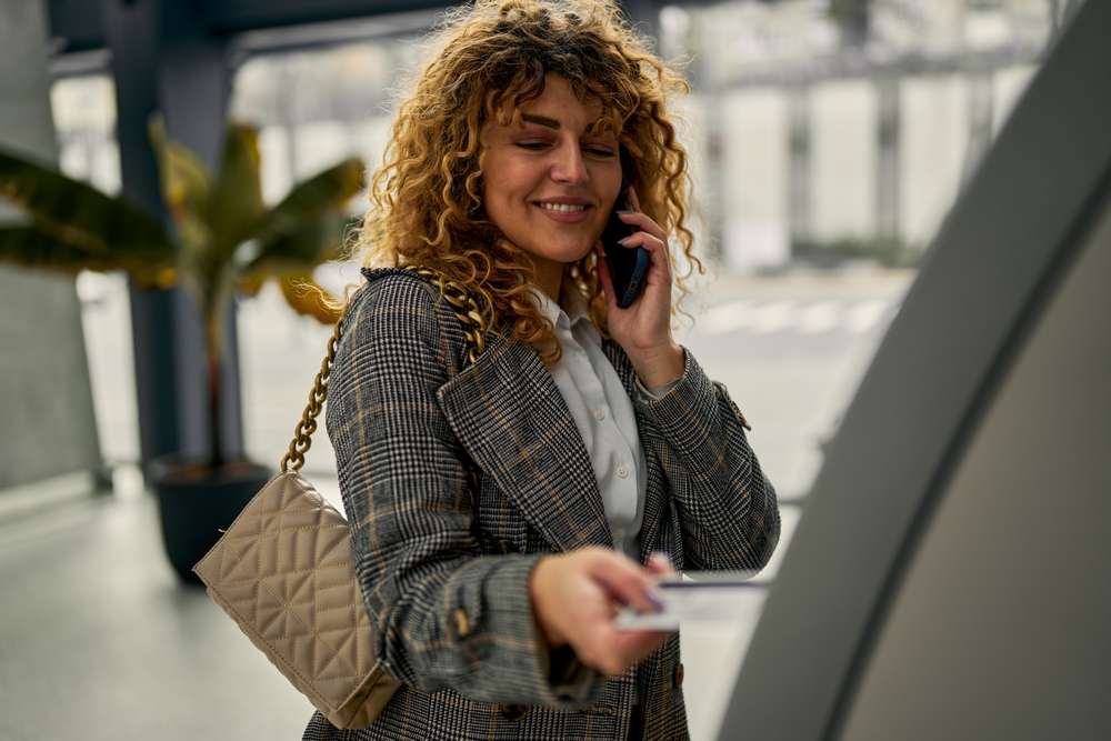 A woman using an international ATM at the airport