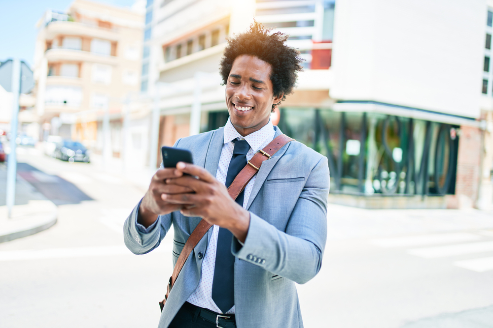 A businessman looks at his phone while using Dave app.